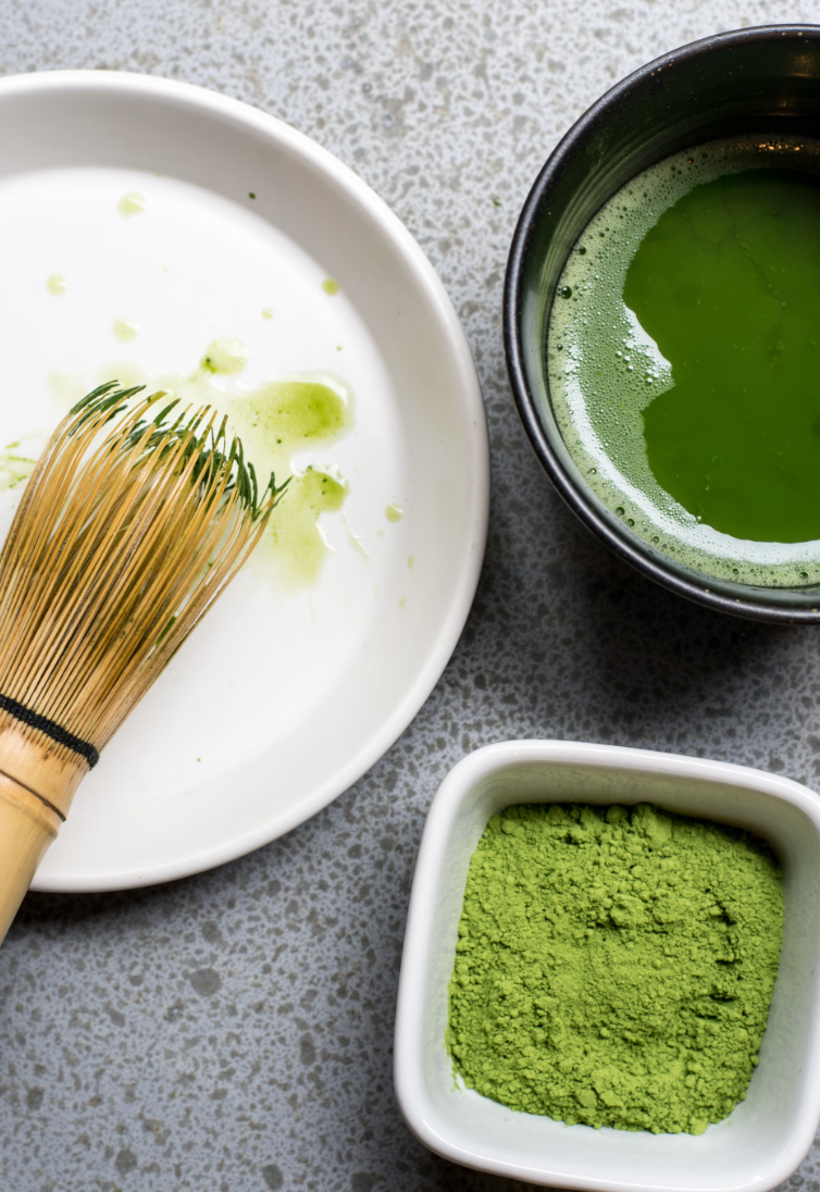 matcha powder, matcha whisk and a matcha latte