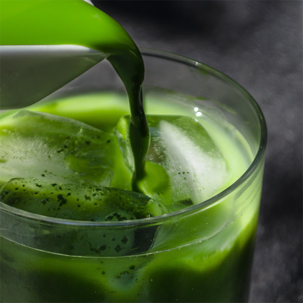 Matcha being poured over a glass of ice 