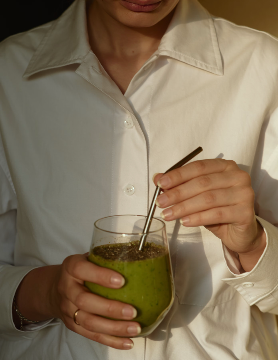 woman drinking a green smoothie